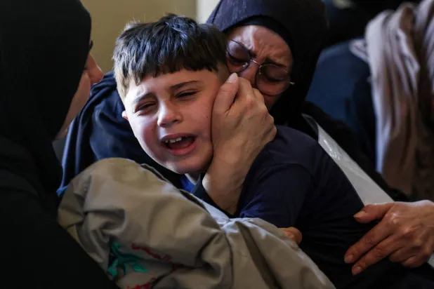طفل يبكي والده الذي قُتل بغارة إسرائيلية استهدفت بلدة دير قانون النهر في جنوب لبنان أثناء تشييع الضحايا (رويترز)