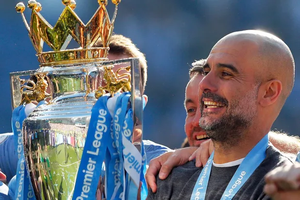 Manchester City coach Pep Guardiola lifts the English Premier League trophy after the English Premier League soccer match between Brighton and Manchester City at the AMEX Stadium in Brighton, England, Sunday, May 12, 2019. (AP)