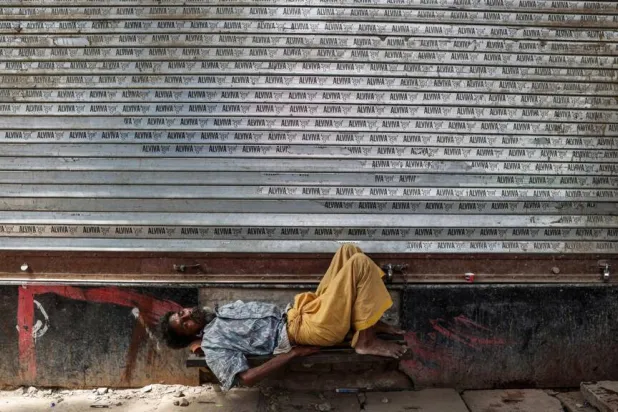 A man takes a nap in front of a closed shop on a hot summer day in Varanasi, in India's Uttar Pradesh, on May 23, 2026. Niharika KULKARNI / AFP
