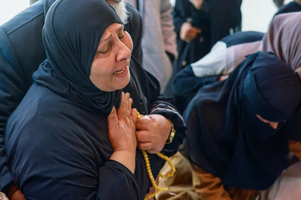 فلسطينية تنتحب خلال جنازة مواطنيها الذين قُتلوا في غارة إسرائيلية على منزل وسط قطاع غزة يوم الأحد (رويترز)