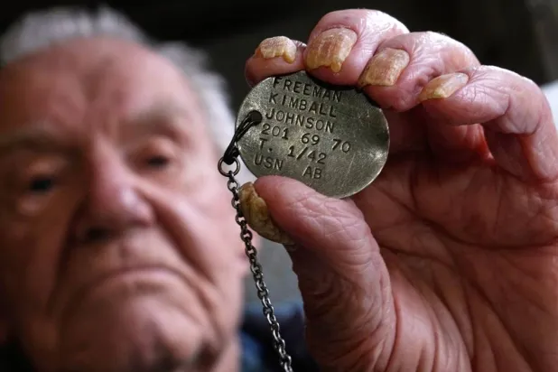  Freeman K. Johnson, a 106-year-old Pearl Harbor survivor, holds up his dog tag, May 6, 2026, in Centerville, Mass. (AP) 