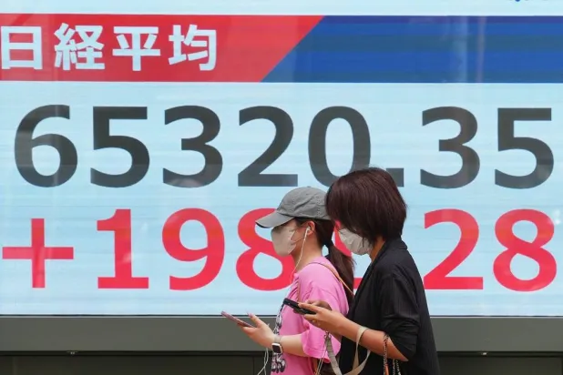  People walk in front of an electronic stock board showing Japan's Nikkei index at a securities firm Monday, May 25, 2026, in Tokyo. (AP) 