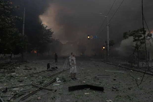 A man standing in smoke looks at heavily damaged buildings following Russian strikes in Kyiv on May 24, 2026, amid the Russian invasion of Ukraine. (AFP) 