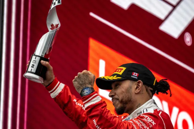 Ferrari's British driver Lewis Hamilton holds his second place trophy as he celebrates on the podium at the conclusion of the 2026 Formula 1 Grand Prix du Canada at Circuit Gilles-Villeneuve in Montreal, Canada, on May 24, 2026. (AFP) 