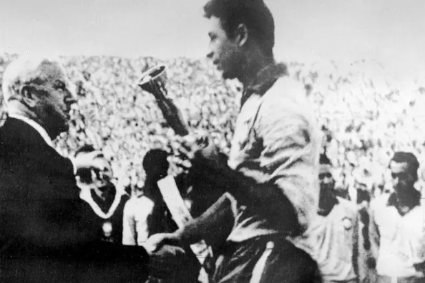 رئيس الاتحاد الدولي الإنجليزي ستانلي راوس يسلم كأس العالم 1962 لقائد البرازيل ماورو (أ.ف.ب)