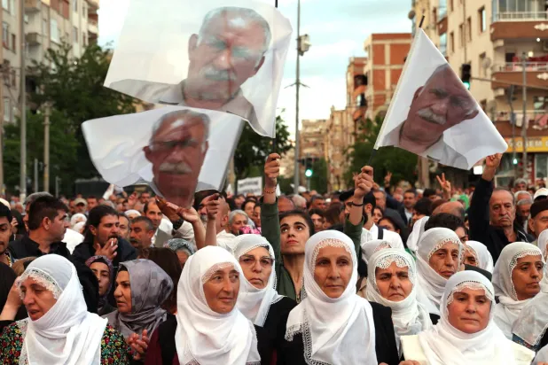 أكراد يرفعون صورة أوجلان خلال مسيرة من أجل السلام في ديار بكر جنوب شرقي تركيا مطالبين بإطلاق سراحه (رويترز)
