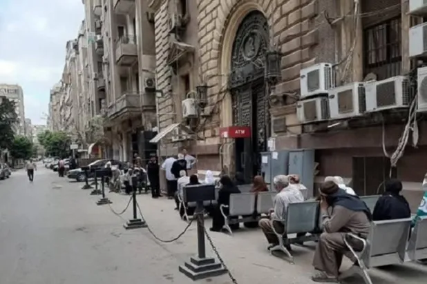 مصريون أمام أحد بنوك وسط القاهرة لصرف معاشاتهم (أرشيفية - صفحة وزارة التضامن الاجتماعي المصرية على «فيسبوك»)