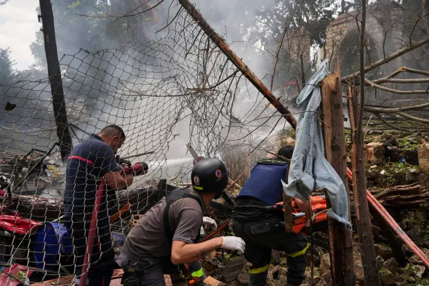 Firefighters work at a strike scene in southern Lebanon, following an Israeli strike on Kfar Roummane, Lebanon May 25, 2026. REUTERS/Stringer