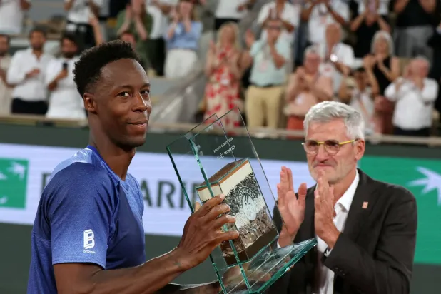 France's Gael Monfils (L) poses with a trophy next to French Tennis Federation's President Gilles Moretton (R) during a ceremony honoring his career on day 2 of the French Open tennis tournament on Court Philippe-Chatrier at the Roland-Garros Complex in Paris on May 25, 2026. (Photo by ALAIN JOCARD / AFP)