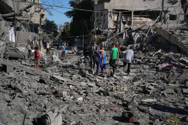 Palestinians inspect the rubble of a building destroyed in an Israeli airstrike in Nuseirat, central Gaza Strip, Tuesday, May 26, 2026. (AP Photo/Abdel Kareem Hana)