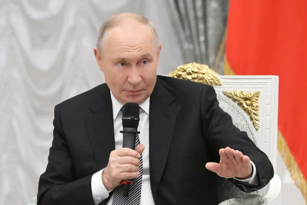 In this pool photograph distributed by the Russian state agency Sputnik, Russia's President Vladimir Putin meets with graduates of the "Time of Heroes" program, at the Kremlin in Moscow on May 22, 2026. (Photo by Alexey NIKOLSKY / POOL / AFP)