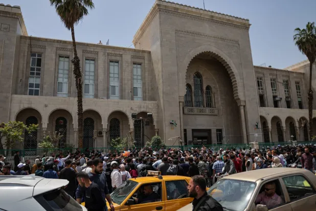 جمهرة خارج «قصر العدل» يوم محاكمة عاطف نجيب المتهم بارتكاب جرائم حرب في 26 أبريل 2026 (رويترز)