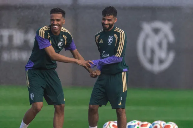 الجوير يمازح زميله أبو الشامات خلال المعسكر (المنتخب السعودي)