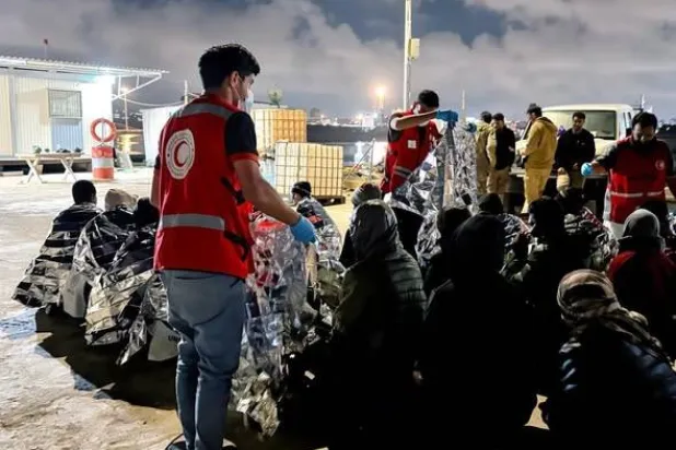 متطوعون من الهلال الأحمر الليبي يقدمون مساعدات إنسانية لمهاجرين غير نظاميين في ساحل مدينة طبرق الليبية (الصفحة الرسمية للهلال الأحمر)