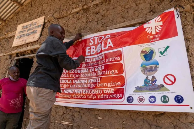 A man hangs an Ebola awareness banner in the Kigonze camp in Bunia, in the eastern Democratic Republic of the Congo, on May 28, 2026. (AFP)