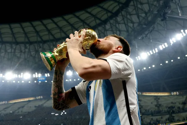 ميسي يقبل كأس العالم 2022 (رويترز)