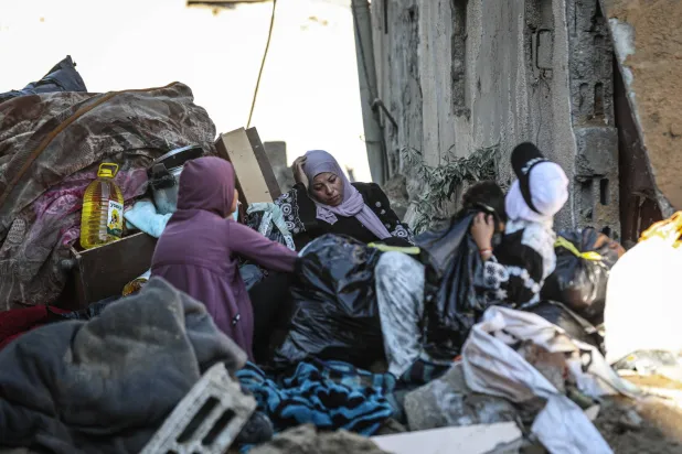 فلسطينيات وسط دمار مبنى استهدفته غارة جوية إسرائيلية في دير البلح وسط قطاع غزة الجمعة (د.ب.أ)