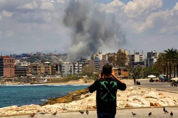 29 May 2026, Lebanon, Tyre: A Lebanese takes video footages of an Israeli air strike on the southern Lebanese port city of Tyre as Israeli forces continued to expand their invasion in south Lebanon amid ongoing direct talks between Lebanon and Israel in Washington. Photo: Stringer/dpa