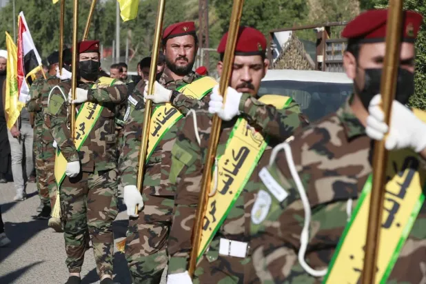 Fighters carry flags of Iraq and paramilitary groups, including Kataib Hezbollah, during a funeral in Baghdad for five militants killed in a US strike in northern Iraq, on Dec. 4, 2023. (AFP via Getty Images) 