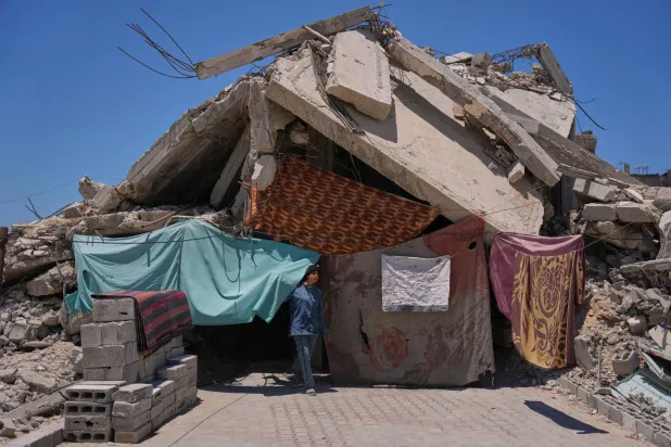 فلسطينية تقف يوم الجمعة الماضي أمام حطام منزل أسرتها الذي دمره الجيش الإسرائيلي في خان يونس جنوب غزة (أ.ب)