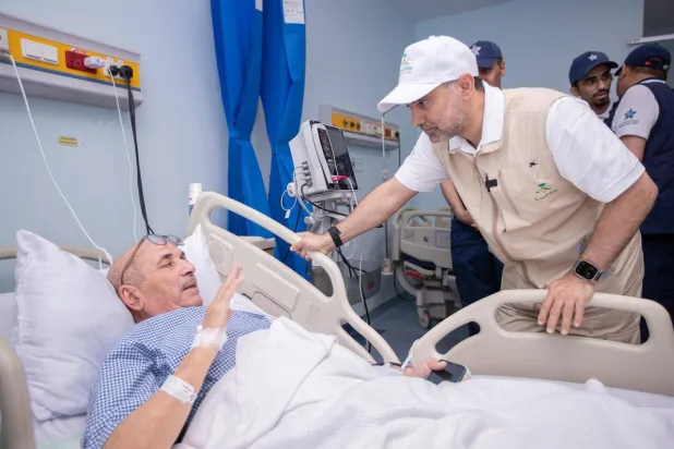 فهد الجلاجل خلال اطمئنانه على صحة أحد الحجاج ضمن جولاته لمتابعة أعمال المستشفيات والمراكز الصحية في المشاعر المقدسة (الصحة السعودية)