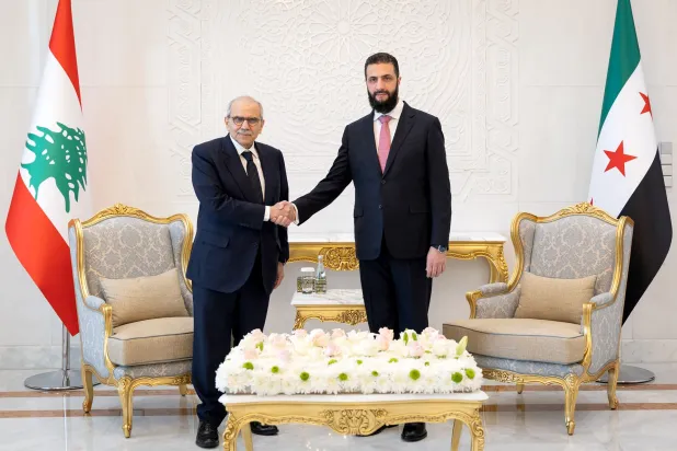 This handout photo provided by Syria's SANA news agency's Telegram channel on May 9, 2026, shows Syrian President Ahmed al-Sharaa (R) shakes hands with Lebanese Prime Minister Nawaf Salam at the People's Palace in Damascus. (SANA / AFP)  