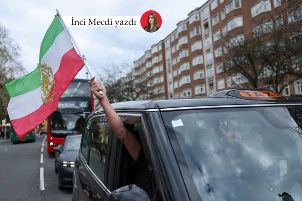Londra'daki İran Büyükelçiliği önündeki rejim karşıtı bir gösteri sırasında bir İranlı protestocu üstünde “Aslan ve Güneş” olan İran bayrağını taşıyor (Reuters)