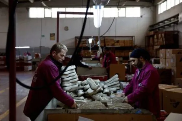 عمال في مصنع شركة «ألكان» لتصنيع نعال الأحذية يعملون داخل المصنع في مجمع «أنطاكيا أوزماني» بولاية هاتاي (رويترز)