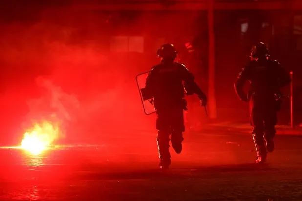 Football - UEFA Champions League - Paris St Germain fans celebrate winning the UEFA Champions League - Paris, France - May 31, 2026 Police officers protect themselves from a flare after Paris St Germain won the UEFA Champions League. (Reuters)