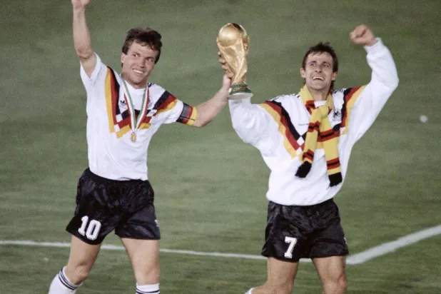 الألمانيان لوتار ماتيوس وبيار ليتبارسكي يحملان كأس العالم 1990 (أ.ف.ب)
