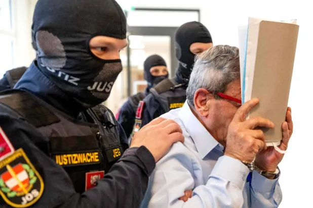 جنرال سوري سابق يدخل قاعة محكمة فيينا الإقليمية في النمسا الاثنين حيث يحاكَم وضابط شرطة سوري كبير بتهمة تعذيب معارضي نظام الأسد المخلوع (أ.ف.ب)