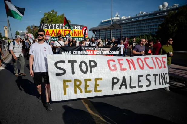 متظاهرون مؤيدون للفلسطينيين ضد السياح الإسرائيليين بعد وصولهم إلى أثينا (أ.ف.ب)