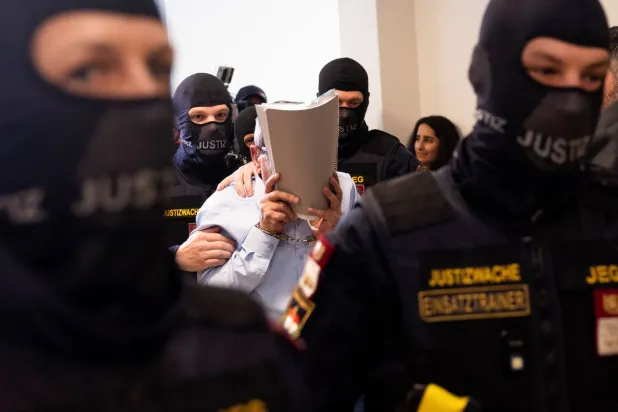 جنرال سوري سابق يدخل قاعة محكمة فيينا الإقليمية في النمسا الاثنين حيث يحاكَم وضابط شرطة سوري كبير بتهمة تعذيب معارضي نظام الأسد (أ.ف.ب)