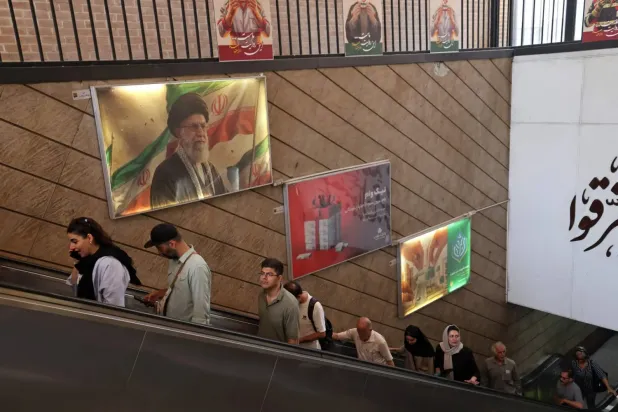 3 Haziran 2026’da Tahran’daki bir metro istasyonundan çıkan insanlar… Arka planda Ayetullah Ali Hamaney’in resmi görülüyor. (AFP)