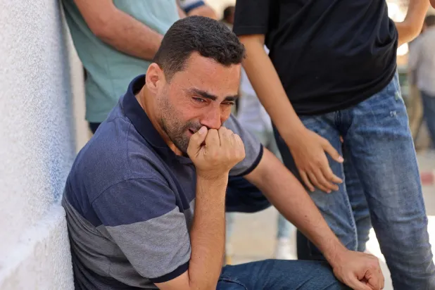 فلسطيني يبكي خلال تشييع ضحايا غارات إسرائيلية من مستشفى الشفاء في مدينة غزة الخميس (أ.ف.ب)

