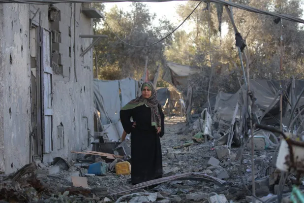 فلسطينية في مكان قصفته إسرائيل بعد تحذير سكان بإخلاء منزلهم في بلدة الزوايدة وسط قطاع غزة (أ.ف.ب)