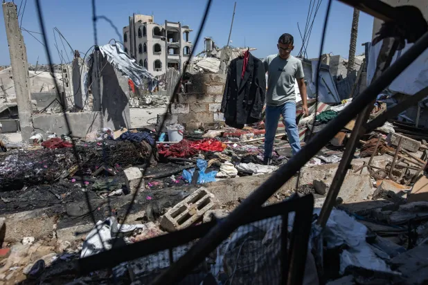 فلسطيني يحمل جاكيت الشاب مهند فروانة الذي قتلته غارة إسرائيلية بينما كان يتجهز لحفل زفافه ظهر اليوم في خان يونس جنوب قطاع غزة (إ.ب.أ)