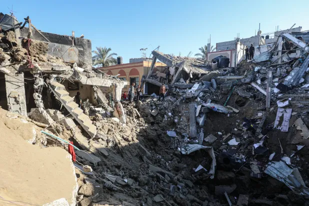 فلسطينيون يعاينون ركام مبنى استهدفته غارة جوية إسرائيلية في دير البلح وسط قطاع غزة 29 مايو 2026 (د.ب.أ)