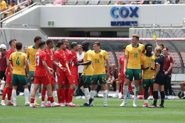 الحكمة إيكاترينا كوروليفا تشهر البطاقة الصفراء في وجه الأسترالي نيستور إيرانكوندا خلال المباراة الودية بين أستراليا وسويسرا (أ.ف.ب)