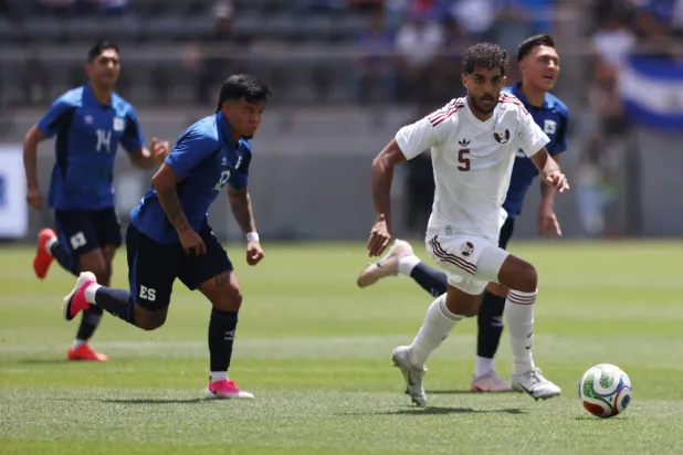 جاسم جابر لاعب منتخب قطر يحاول لعب الكرة تحت ضغط مارسيلو دياز لاعب السلفادور (أ.ف.ب)