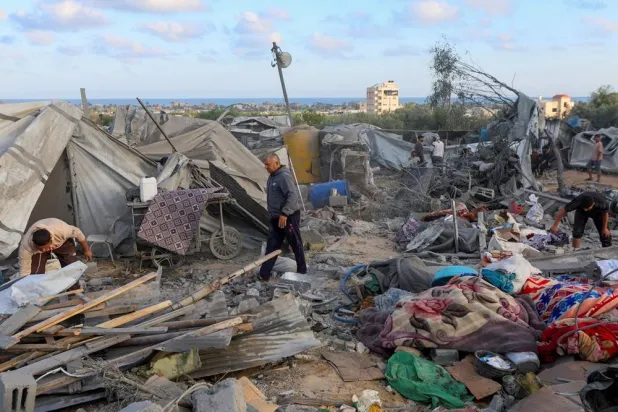  Palestinians inspect the damage to a tent camp sheltering displaced people in the aftermath of an Israeli strike on a nearby house whose residents were warned to evacuate before the attack, in Khan Younis in the southern Gaza Strip June 7, 2026. (Reuters)