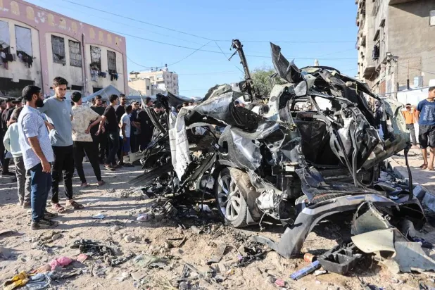 Palestinians look at the wreckage of a car hit by an Israeli airstrike in Gaza City on June 7, 2026. (AFP)