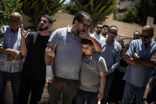 Fahd Abou Haikal, a Palestinian man comforts his elder son Kinan Abou Haikal after burying his seven-month-old baby Sam Fahd Abou Haikal, in Hebron, in the occupied West Bank on June 6, 2026. (AFP)