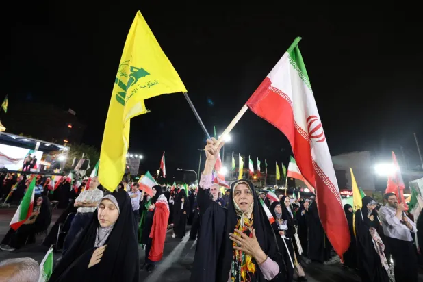 متظاهرون إيرانيون مؤيدون للحكومة يرفعون أعلام إيران و«حزب الله» بعد غارات إسرائيلية على الضاحية الجنوبية لبيروت في طهران في 7 يونيو 2026 (أ.ف.ب)