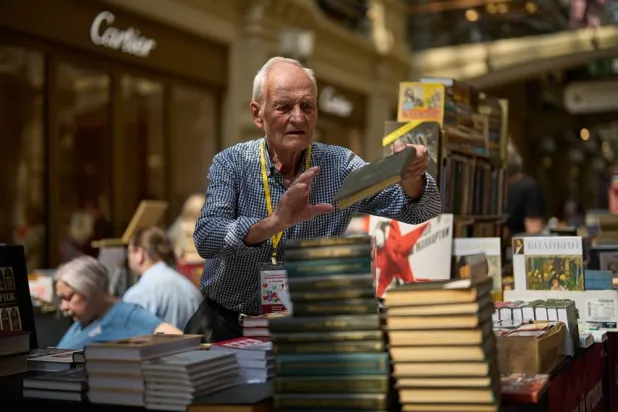  A bookseller holds a book while standing at a book shop in the GUM department store, during the annual Red Square Book Festival, celebrating Alexander Pushkin's birthday in Moscow, on Friday, June 5, 2026. (AP) 