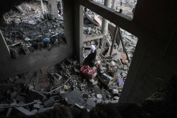 A Palestinian woman stands amid debris at the site of an Israeli airstrike in Khan Younis, southern Gaza Strip, on June 7, 2026. (AFP)