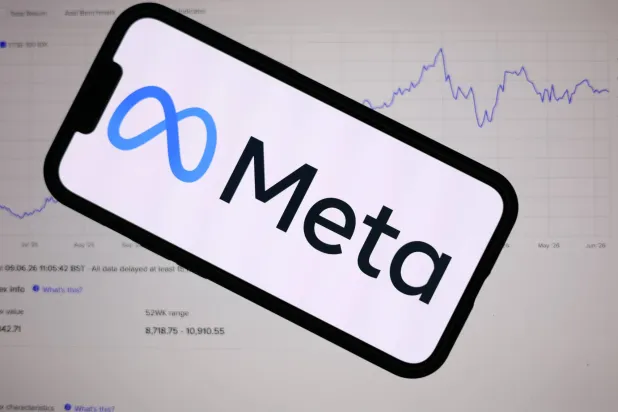 The Meta logo is displayed on a mobile phone over a stock market graph displayed on a laptop screen in Liverpool, Britain, 09 June 2026. EPA/ADAM VAUGHAN