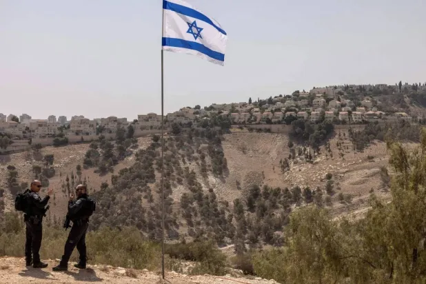 شرطيان إسرائيليان يقفان في منطقة «إي 1» قرب مستوطنة «معاليه أدوميم» خارج القدس في الضفة الغربية (أرشيفية - أ.ف.ب)