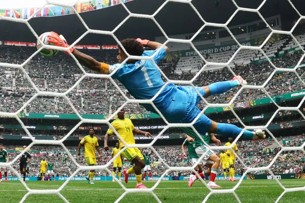 حارس منتخب جنوب أفريقيا رونوين ويليامز يتصدى لإحدى المحاولات المكسيكية (رويترز)