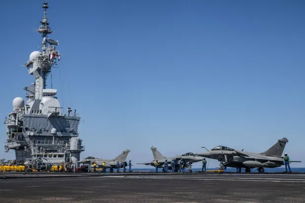 (FILES) This photograph taken on April 27, 2026, shows Rafale fighter aircraft parked on the flight deck of the French aircraft carrier Charles de Gaulle during the NATO military exercise Neptune Strike 26-2, off the coast of the Greek island of Crete. (Photo by Angelos TZORTZINIS / AFP)